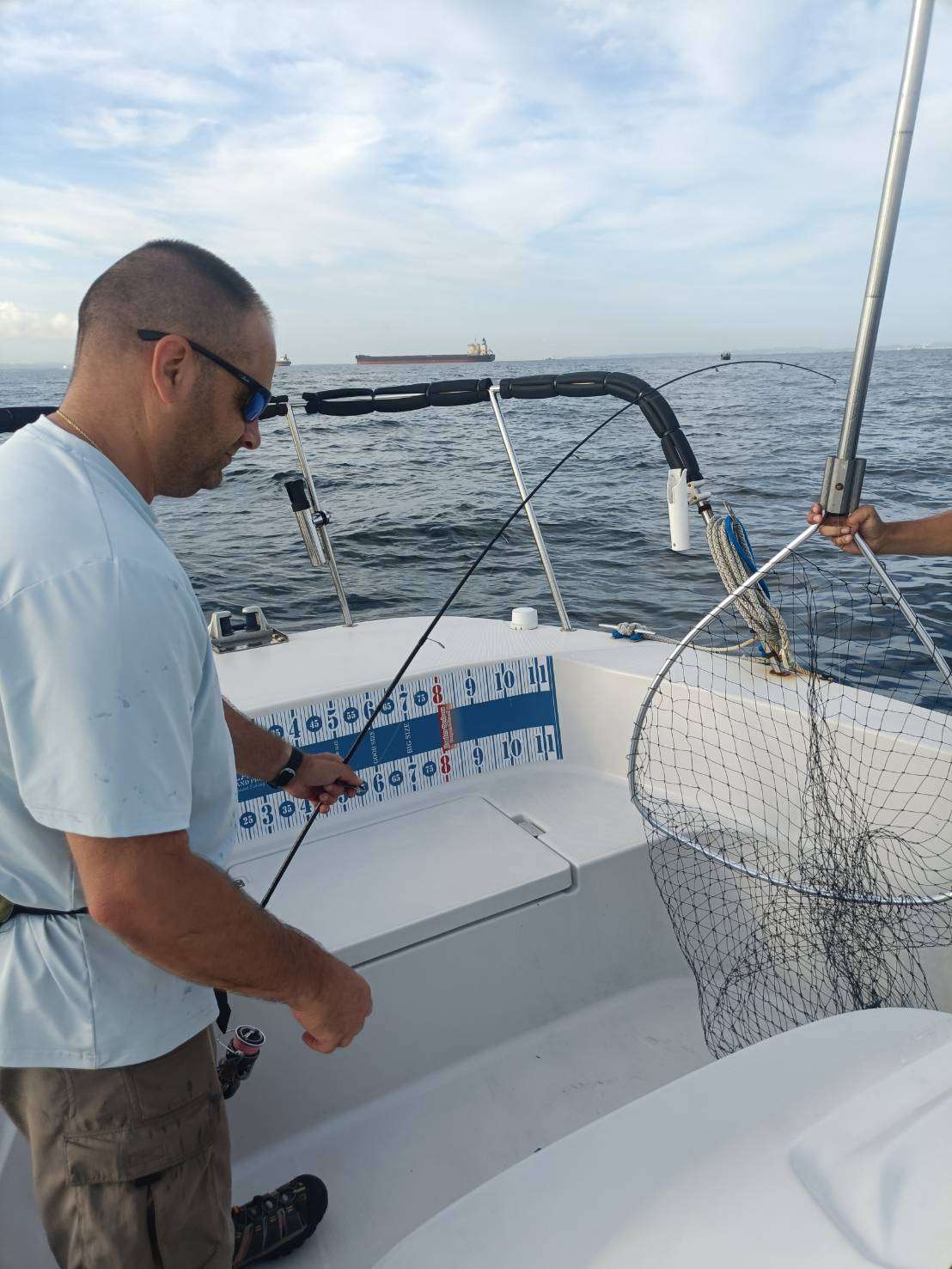 Mr. Jim fishing as Captain Sato prepares the landing net on Tokyo Bay