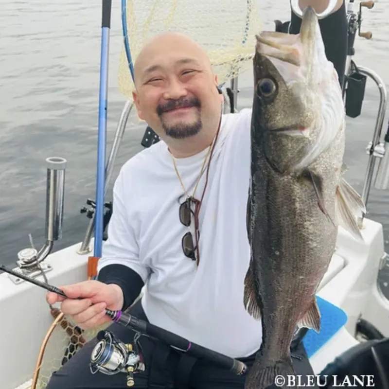Guest smiling with a Japanese sea bass