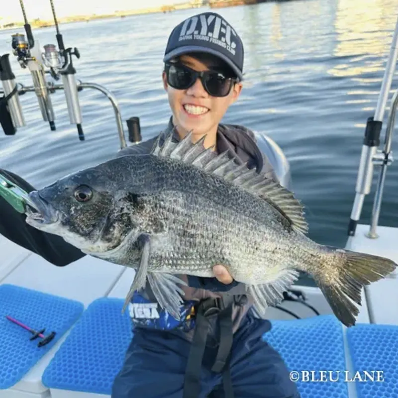 Guest smiling with a catch aboard BLEU LANE